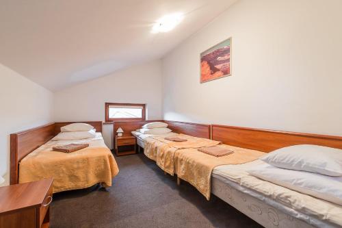 a room with three beds and a table and a mirror at Wołosań B&B in Cisna