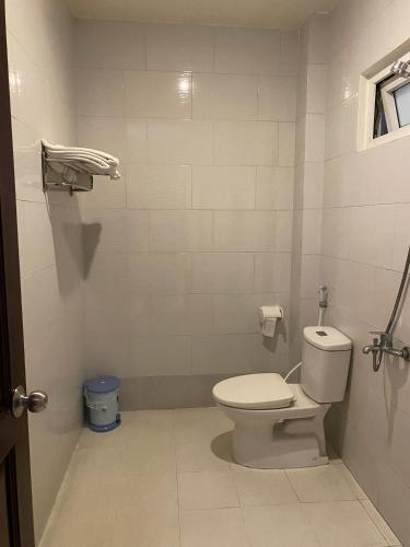a white bathroom with a toilet and a window at KIM BĂNG HOTEL BÌNH DƯƠNG in Thu Dau Mot