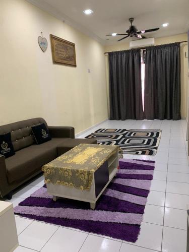 a living room with a couch and a rug at AK PERMATA HOMESTAY in Tanah Merah