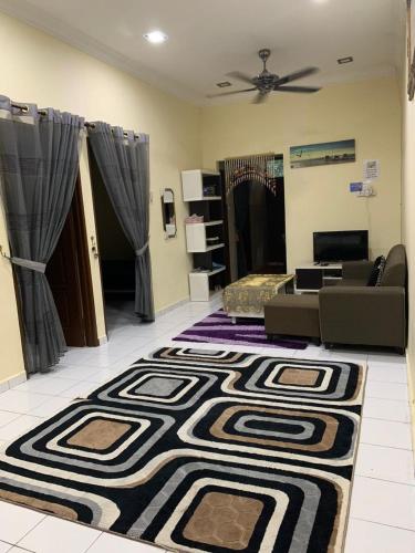 a living room with a couch and a rug at AK PERMATA HOMESTAY in Tanah Merah