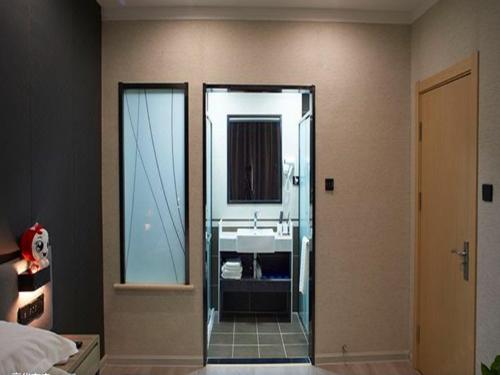 ein Bad mit einem Waschbecken und einem Spiegel in der Unterkunft Thank Inn Plus Hotel Hebei Shijiazhuang Yuhua District of Hebei Normal University in Shijiazhuang