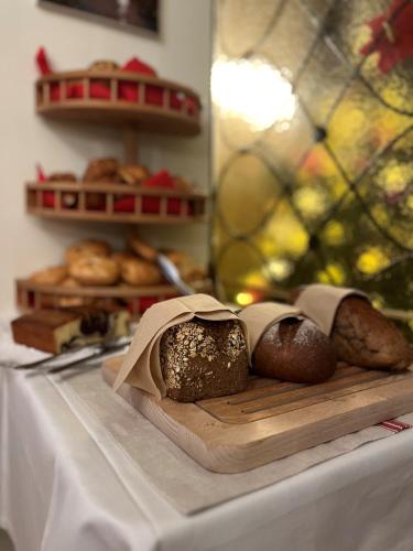 a table with breads and pastries on a cutting board at Hotel Lindenhof in Bad Gastein