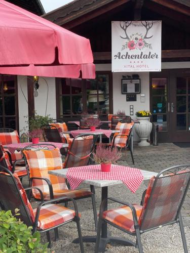 a group of tables and chairs in front of a restaurant at DEVA Achentaler Vitalhotel in Unterwössen