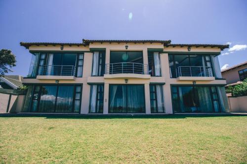 a large house with windows and a yard at Castellon Boutique Hotel in Table View