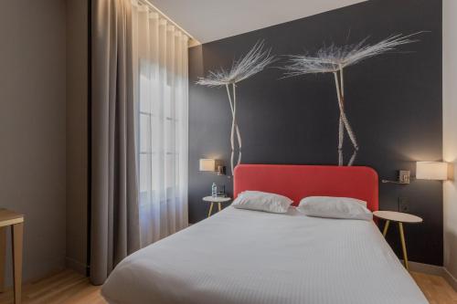 a bedroom with a bed with a red headboard at Ibis Styles Toulouse Capitole in Toulouse