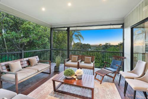 a living room with a couch and chairs on a balcony at Luxury Holiday Home in Alex - Heated Pool - Pets Allowed in Alexandra Headland