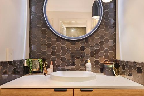 a bathroom with a sink and a mirror at Luxury Holiday Home in Alex - Heated Pool - Pets Allowed in Alexandra Headland