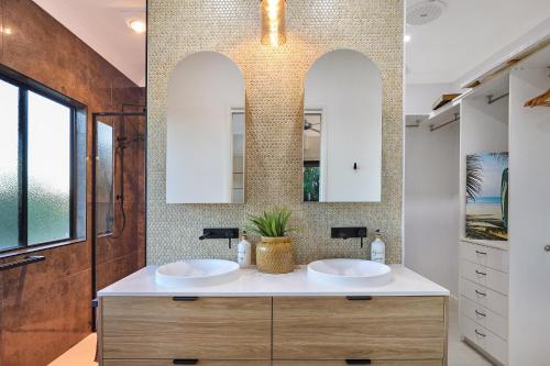 a bathroom with two sinks and two mirrors at Luxury Holiday Home in Alex - Heated Pool - Pets Allowed in Alexandra Headland
