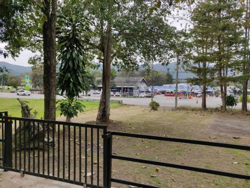 a black fence next to a park with trees at สายฝนการ์เด้น in Ban On Luai