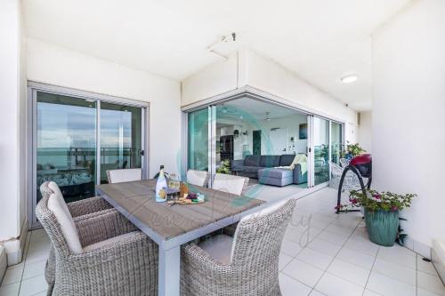 a living room with a table and chairs at ZEN SEA BREEZE - Darwin's Premier Family Apt in Darwin