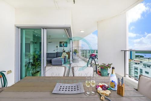 a balcony with a table with wine glasses on it at ZEN SEA BREEZE - Darwin's Premier Family Apt in Darwin