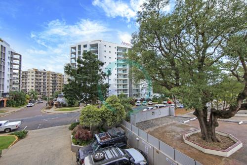 a parking lot with cars parked in front of a building at ZEN SEA BREEZE - Darwin's Premier Family Apt in Darwin