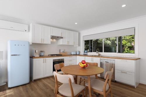 a kitchen with a table with a bowl of fruit on it at Megalong Valley Lookout Cottage in Katoomba