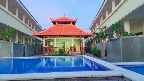a house with a swimming pool in front of a building at THE LAVIANA HOTEL in Lovina