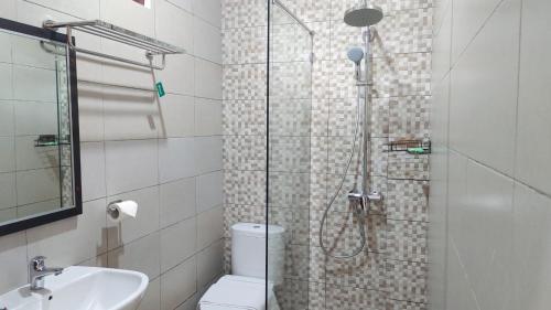a bathroom with a shower and a toilet and a sink at THE LAVIANA HOTEL in Lovina