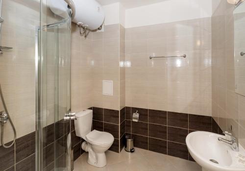 uma casa de banho com um WC, um lavatório e um chuveiro em Seaside Garden 2 Bedroom Apartment For 41 Pax em Sunny Beach
