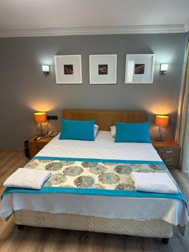 a bedroom with a large bed with blue pillows at Basoglu Bulancak Hotel in Bulancak