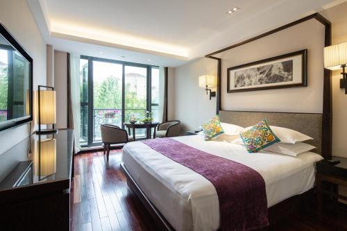 上海的住宿－上海徐汇同文君亭酒店，酒店客房设有一张大床和一张桌子。