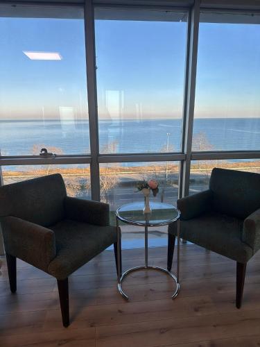 a living room with two chairs and a glass table at Basoglu Bulancak Hotel in Bulancak