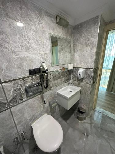 a bathroom with a toilet and a sink at Basoglu Bulancak Hotel in Bulancak