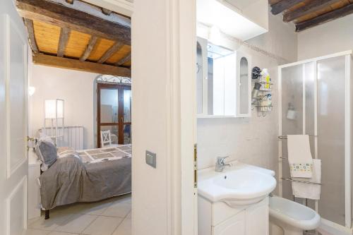 un bagno con lavandino e un letto in una camera di Casa Romantica a Massa