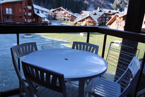 une table et des chaises sur un balcon avec vue dans l'établissement Les Pierres Blanches Contamines Montjoie, aux Contamines-Montjoie