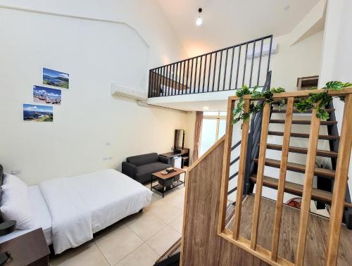 a bedroom with a staircase and a bed in a room at Yuzhou Garden B&B in Taitung City