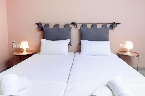 two beds in a room with two lamps on tables at Casa Di Nina in Ýpsos