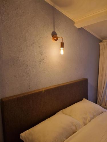 ein Schlafzimmer mit einem Bett und einer Lampe an der Wand in der Unterkunft cottage near the beach in the center.**** in Noordwijk