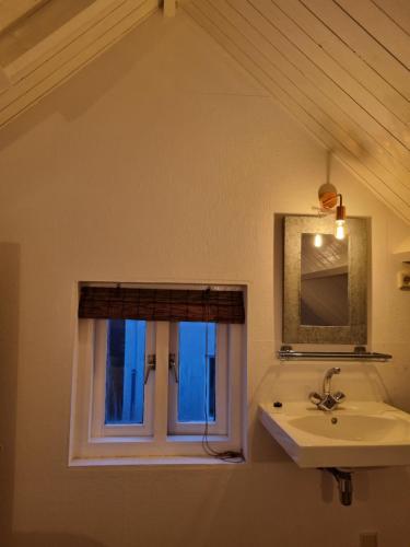 ein Bad mit einem Waschbecken und einem Fenster in der Unterkunft cottage near the beach in the center.**** in Noordwijk