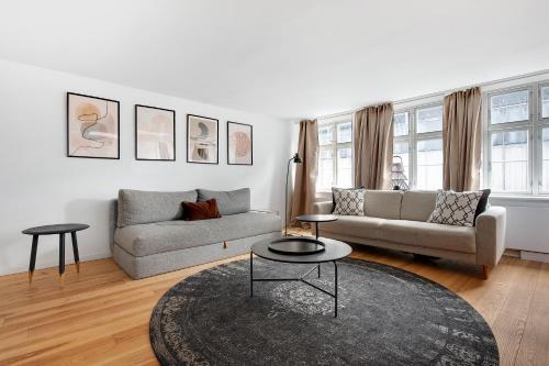 a living room with a couch and a table at Sanders Regent - Treasured Three-Bedroom Apartment Near Central Square in Copenhagen