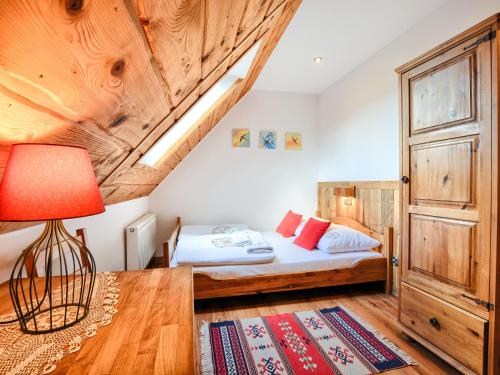 a bedroom with a bed and a wooden ceiling at Gościniec Rabe - Agro&SPA in Ustrzyki Dolne