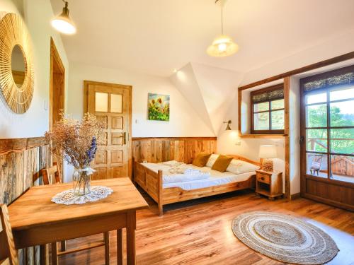 a bedroom with a bed and a table at Gościniec Rabe - Agro&SPA in Ustrzyki Dolne