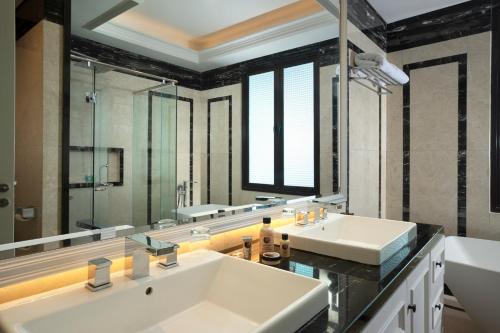 ein Badezimmer mit zwei Waschbecken und einem großen Spiegel in der Unterkunft Panbil Residence Serviced Apartment in Batam Center