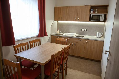 a kitchen with a wooden table and a refrigerator at Penzion Sudomír in Sudoměřice