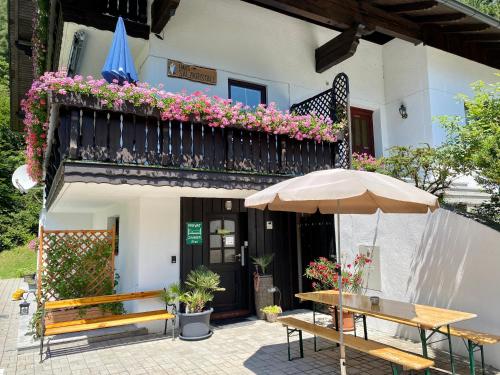 a patio with benches and an umbrella and a building at Haus Salzkristall in Obertraun