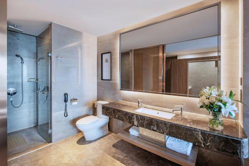 a bathroom with a sink and a toilet and a shower at Mission Hills Hotel Resorts Dongguan in Dongguan