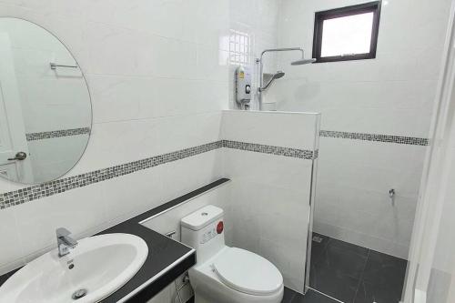 a bathroom with a toilet and a sink and a mirror at Happy Family in Chanthaburi