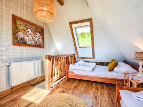 een zolderkamer met 2 bedden en een wieg bij Gościniec Rabe - Agro&SPA in Ustrzyki Dolne