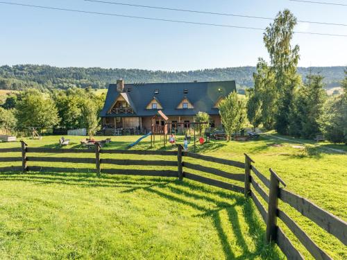 a fence in front of a house with a playground at Gościniec Rabe - Agro&SPA in Ustrzyki Dolne