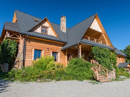 a log home with a black roof at Gościniec Rabe - Agro&SPA in Ustrzyki Dolne