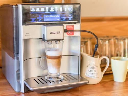 a coffee maker with a glass of coffee at Gościniec Rabe - Agro&SPA in Ustrzyki Dolne