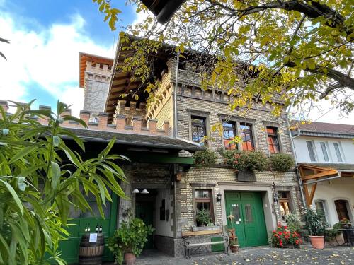 an old house with a green door and flowers at Gästehaus Guntersblum in Guntersblum