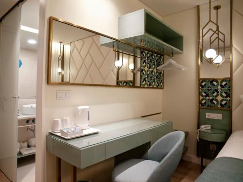 a room with a vanity with a chair and a mirror at New Style Lisbon Hotel in Lisbon