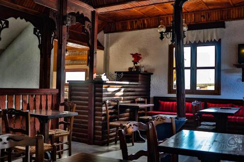 a restaurant with tables and chairs and a red couch at Hotel Mitikas in Livádion