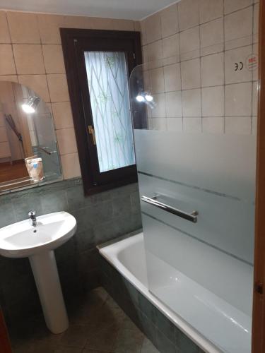 a bathroom with a sink and a bath tub and a sink at L'Artiga in Sesué