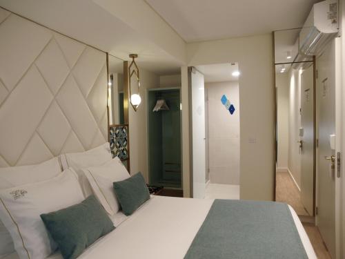 a bedroom with a large white bed with two pillows at New Style Lisbon Hotel in Lisbon