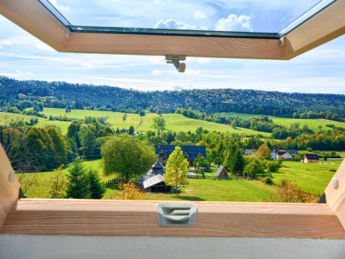 an open window with a view of a green field at Gościniec Rabe - Agro&SPA in Ustrzyki Dolne