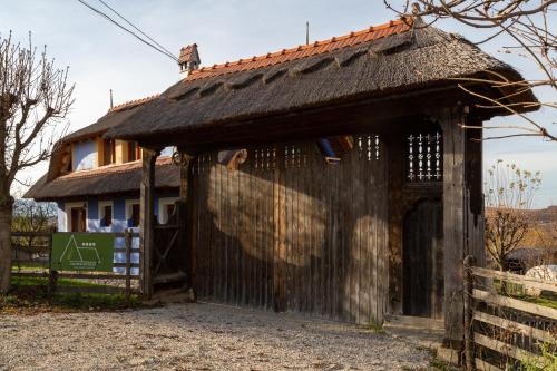 a small house with a gate and a fence at Casele cu Stuf B&B Haus Ulrike in Sălicea