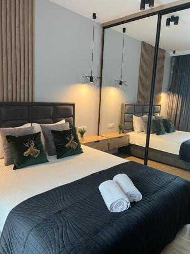 sypialnia z 2 łóżkami i dużym lustrem w obiekcie Apartamentowiec Opole w mieście Opole